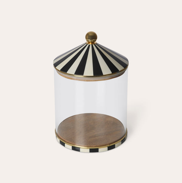 Decorative glass jar with black and white striped lid on a white background
