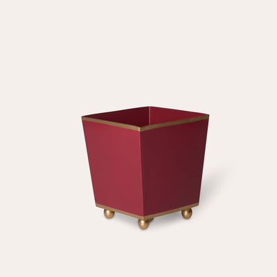 Red cube planter with gold trim and feet on a white background