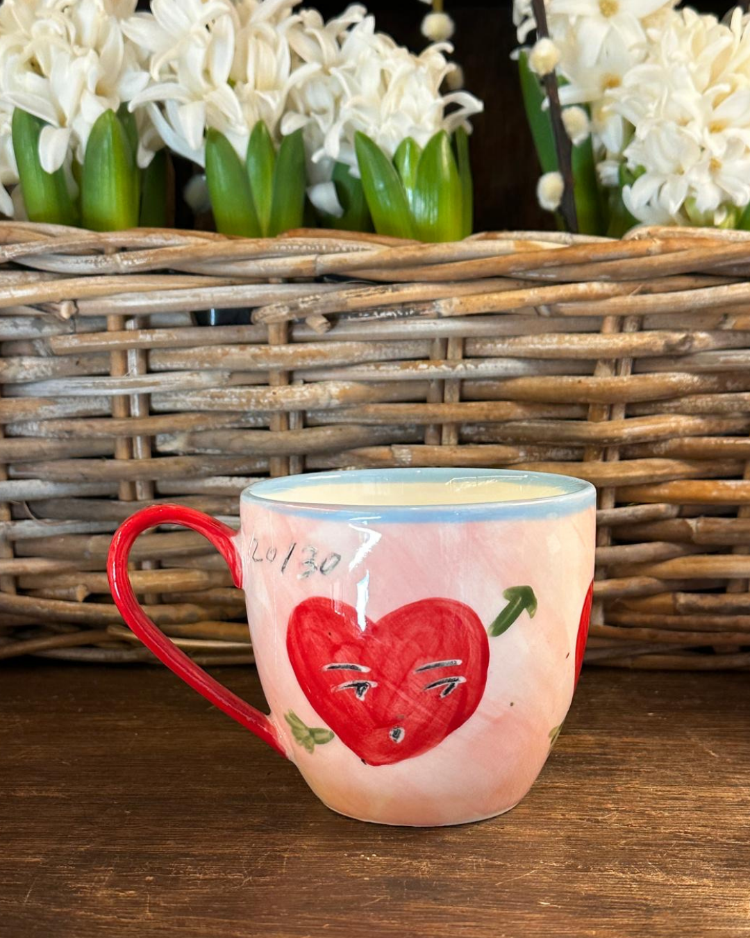 Ceramic mug with a red heart design hand painted by Tatiana Alida for Valentine's gifting