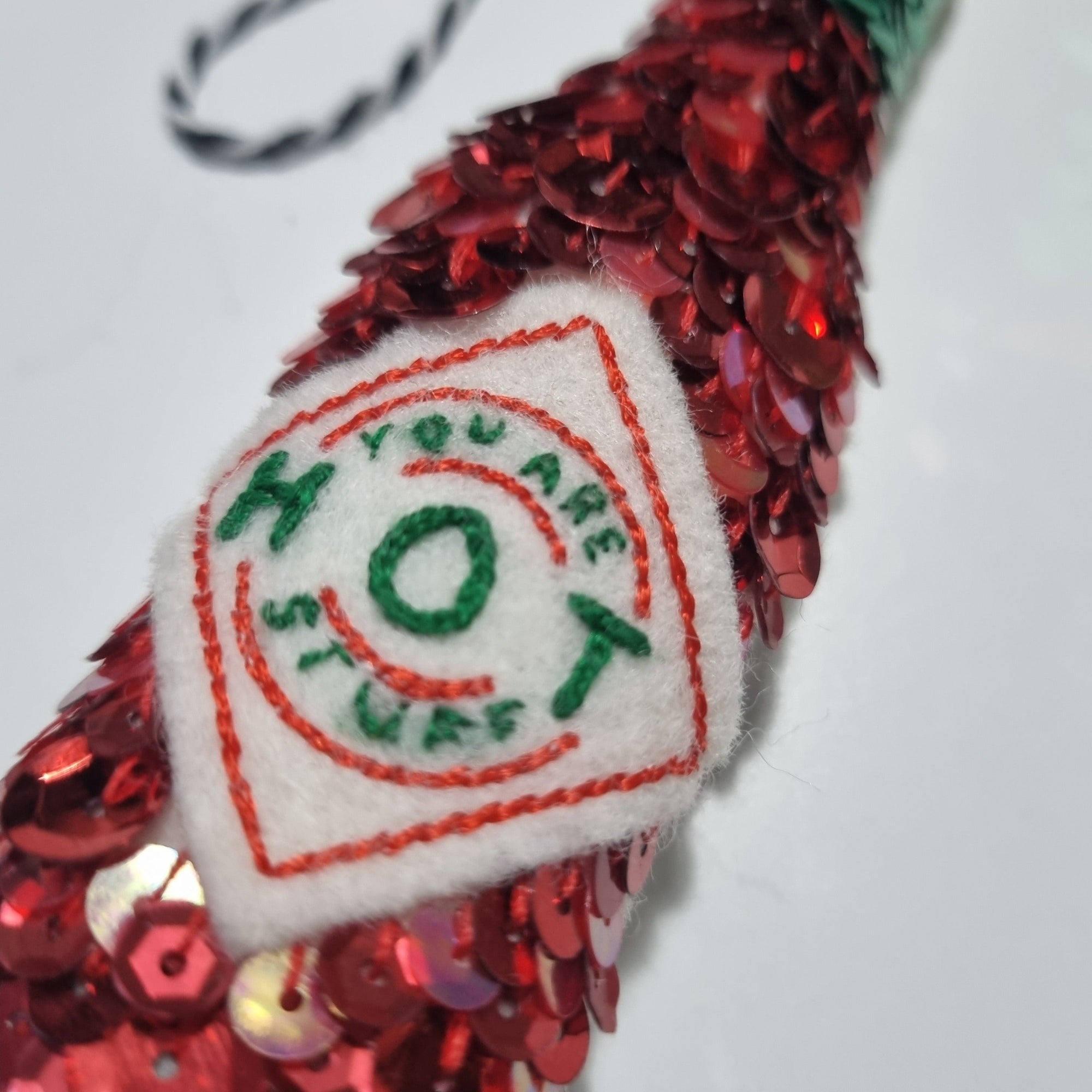 a sequinned tabasco bottle with a label saying you are hot stuff