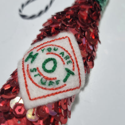 a sequinned tabasco bottle with a label saying you are hot stuff