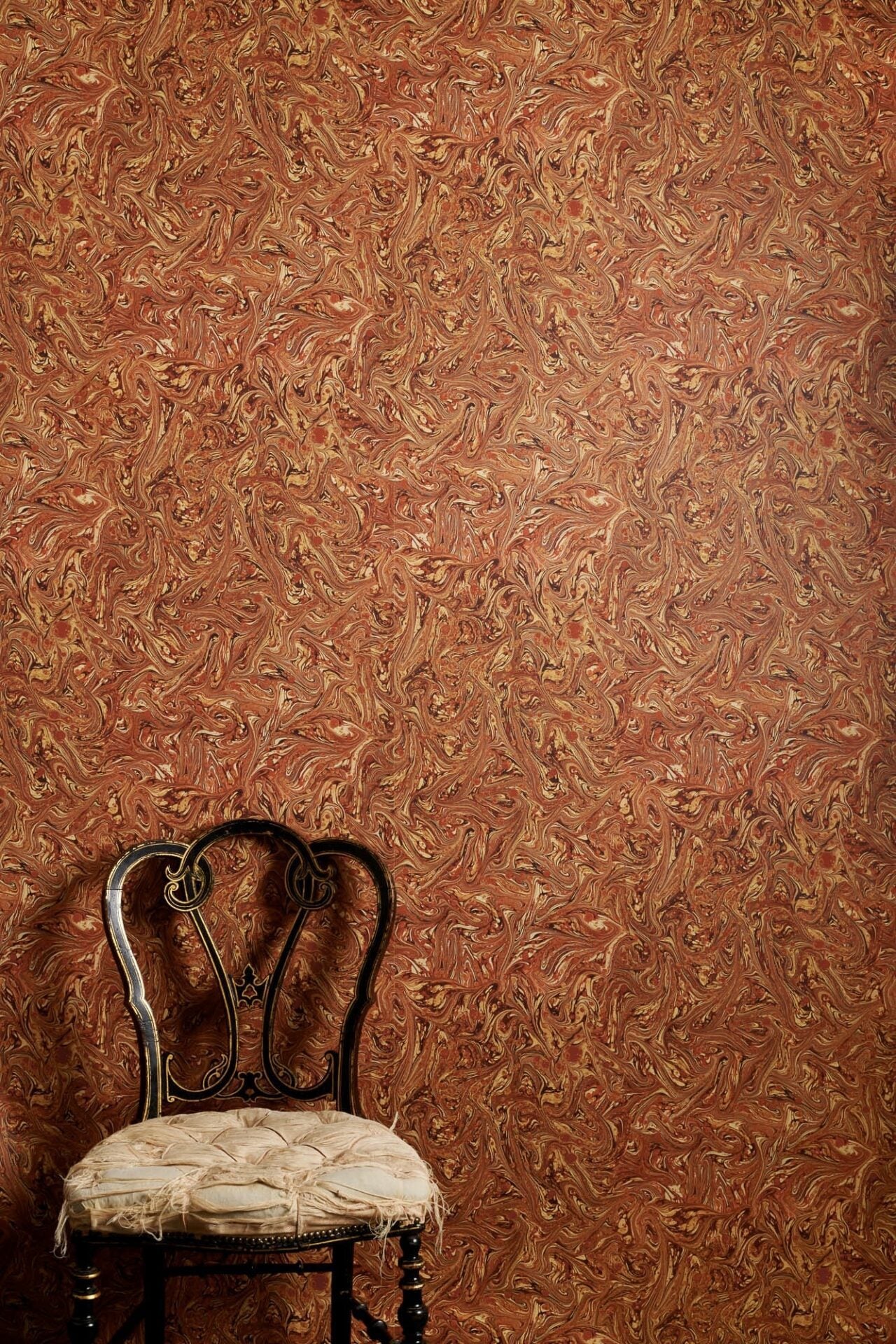 Meredith Rouge marbled wallpaper with dense swirling pattern in rich warm tones printed on wide 70cm roll
