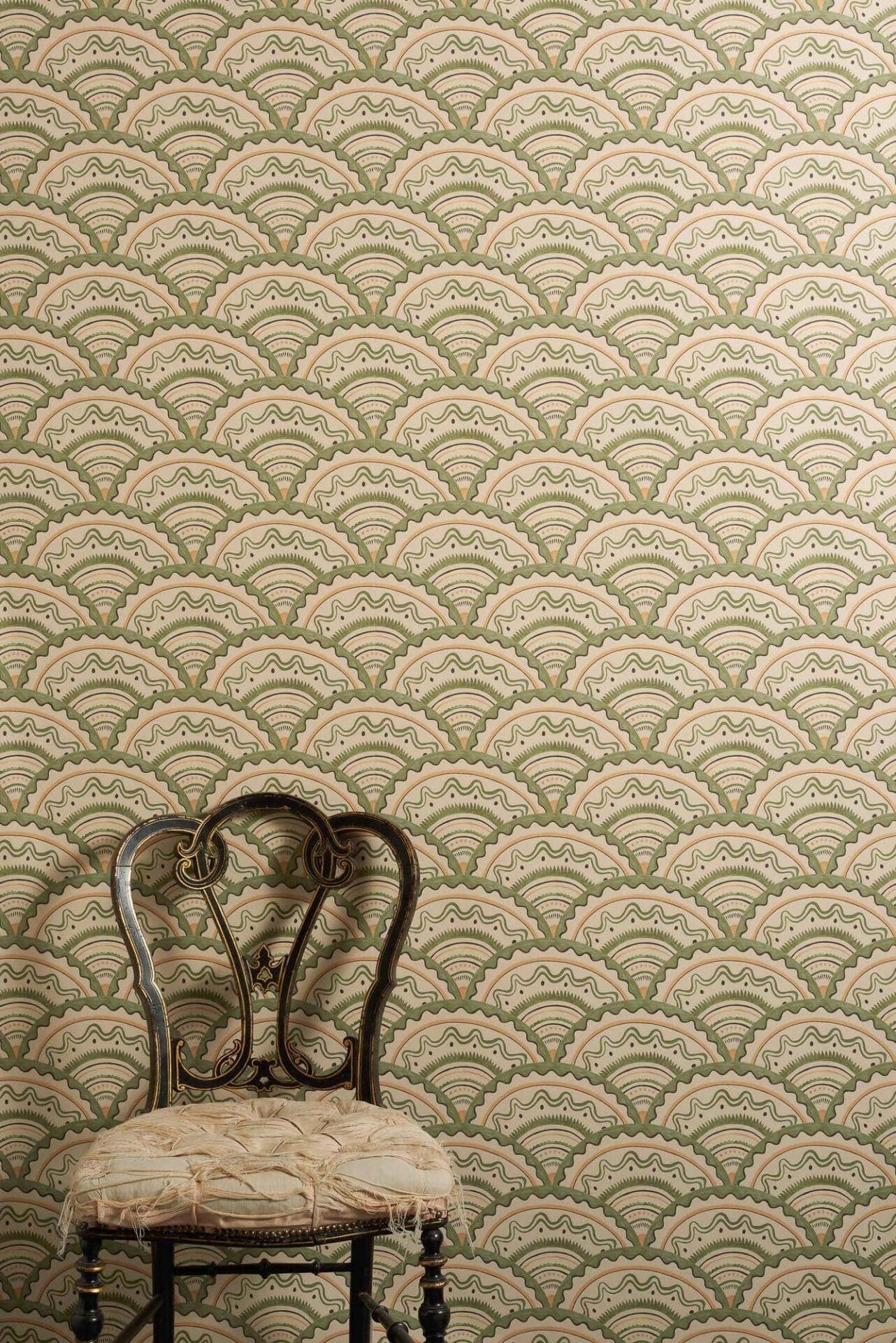 Clarice Verte wallpaper with scalloped geometric pattern in sage green, muted orange and soft black tones inspired by 1930s design