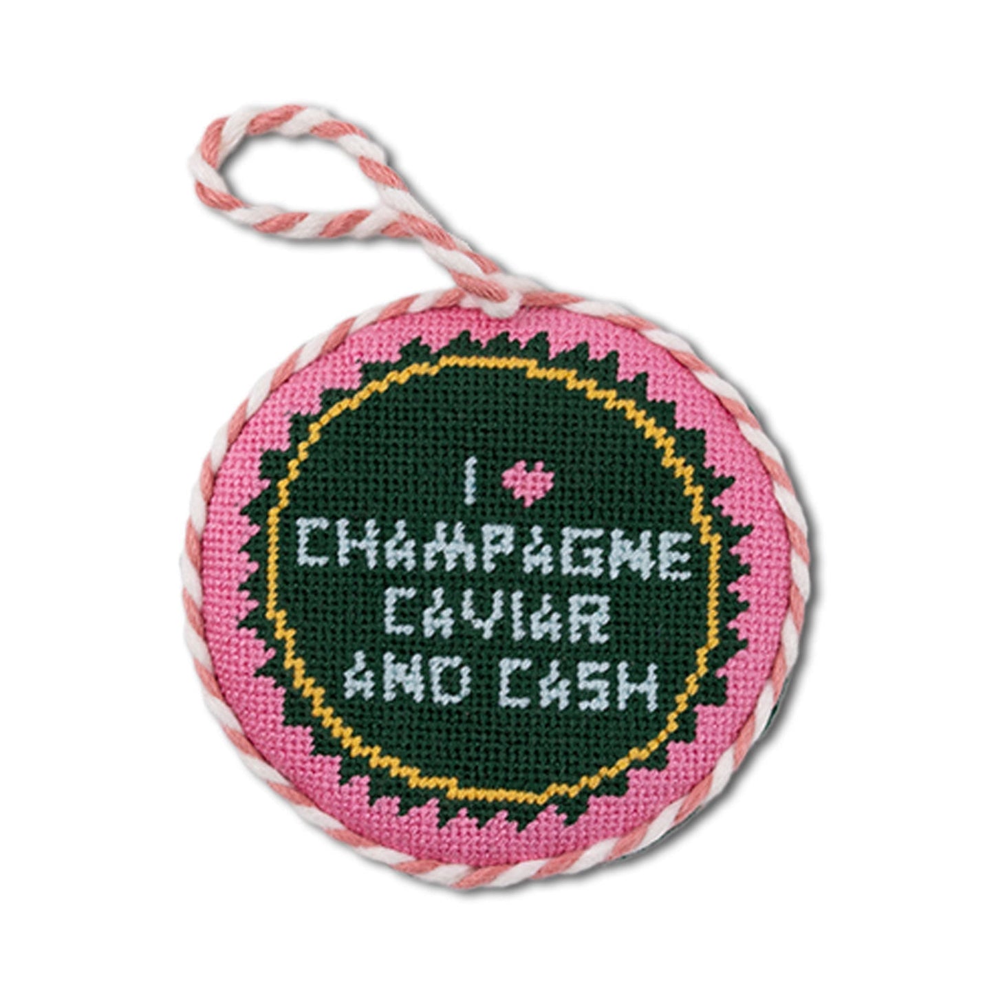 Circular pink object with cross-stitched text and a heart on a white background