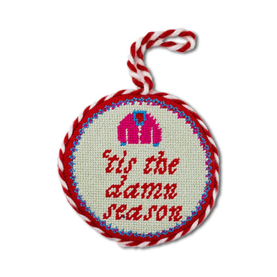 Decorative ornament with 'tis the damn season text and candy cane design on a white background
