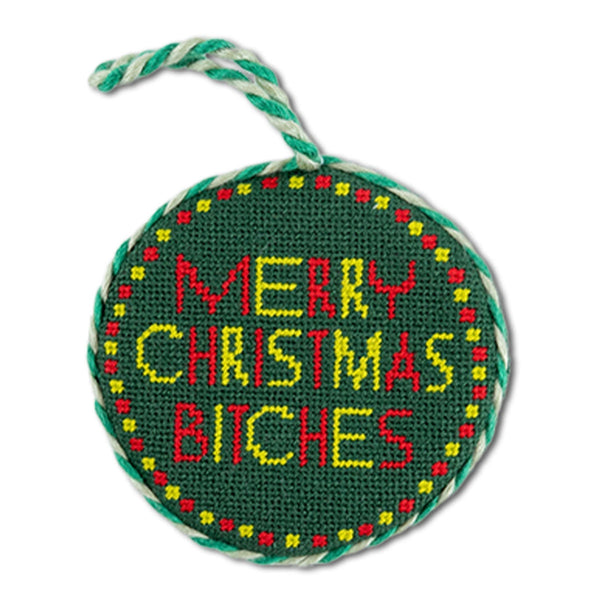 Round green needlepoint ornament with colorful text on a white background