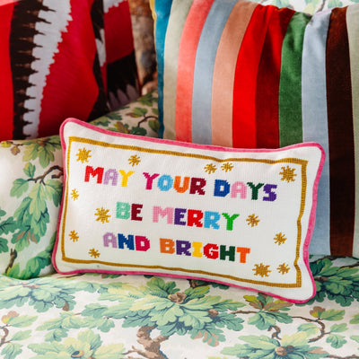 Decorative pillow with colorful text on a floral-patterned couch.