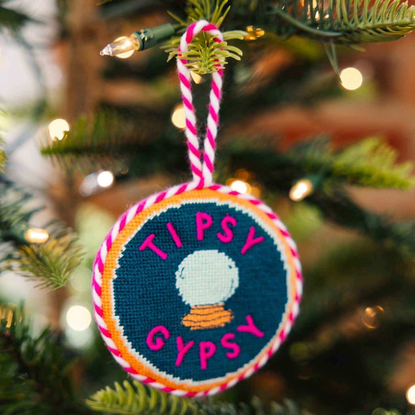 Decorative ornament with 'Tipsy Gypsy' text on a Christmas tree.