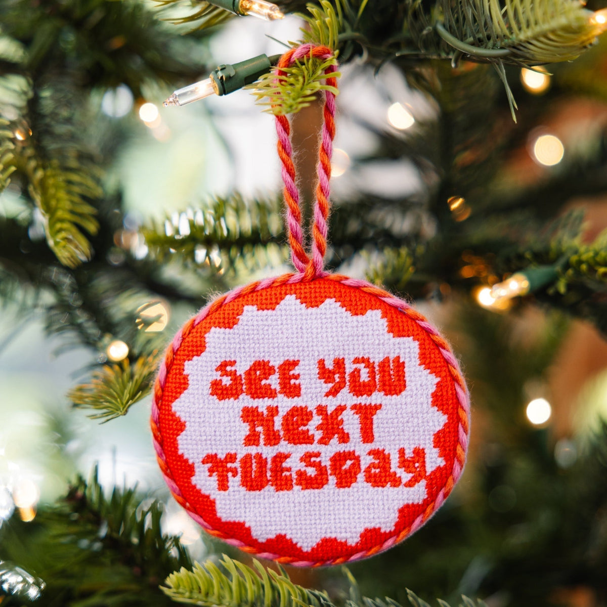 Decorative Christmas ornament with 'See you next Tuesday' text on a tree.