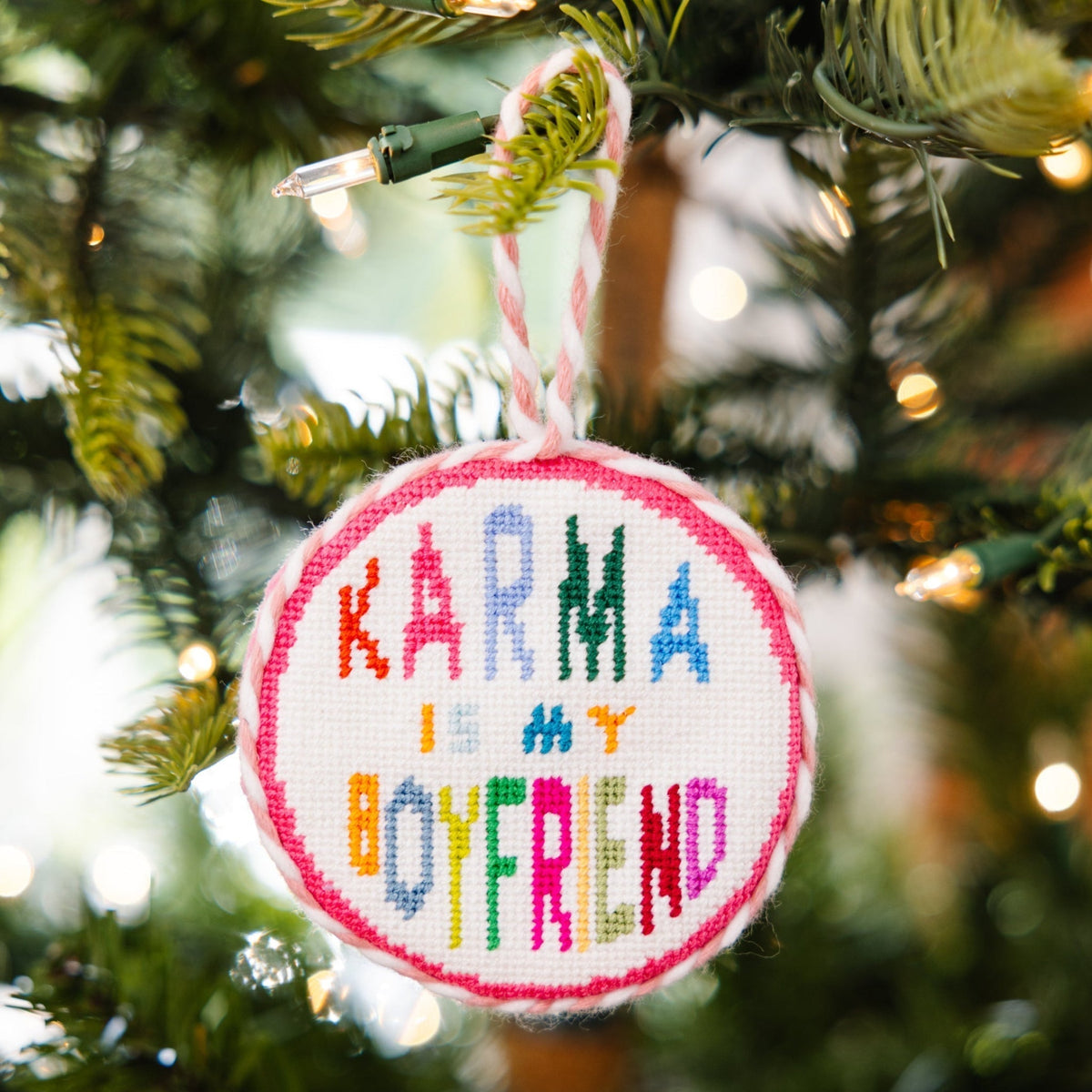 Decorative ornament with 'Karma is my boyfriend' text on a Christmas tree.