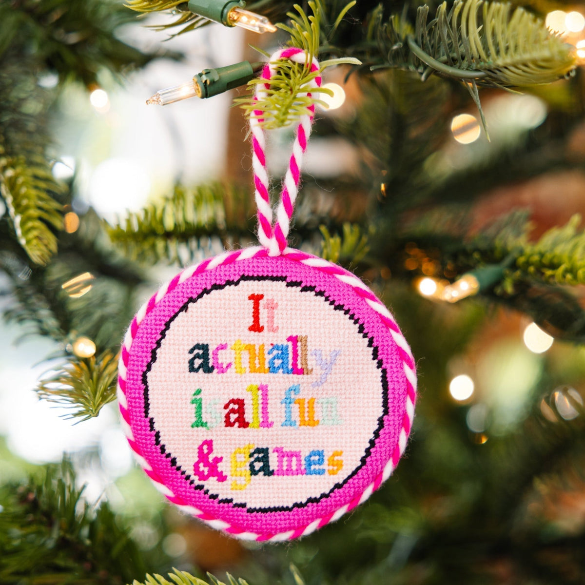 Decorative ornament with colorful text on a Christmas tree