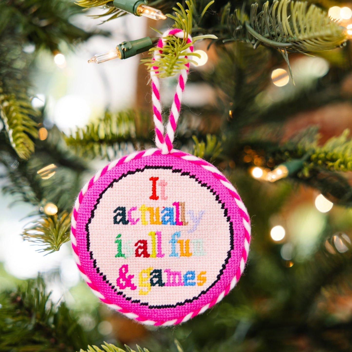 Decorative ornament with colorful text on a Christmas tree