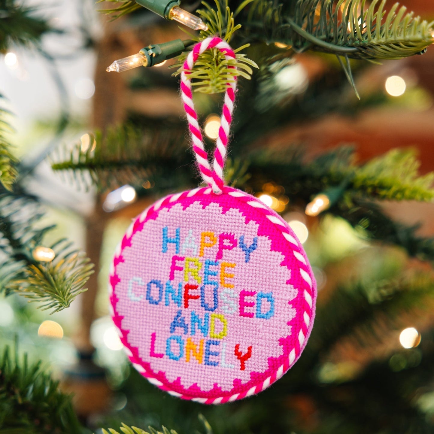 Decorative ornament with colorful text on a Christmas tree