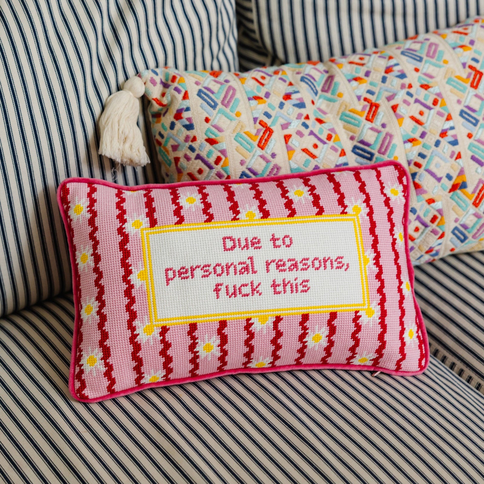 Decorative pillow with text on a striped sofa