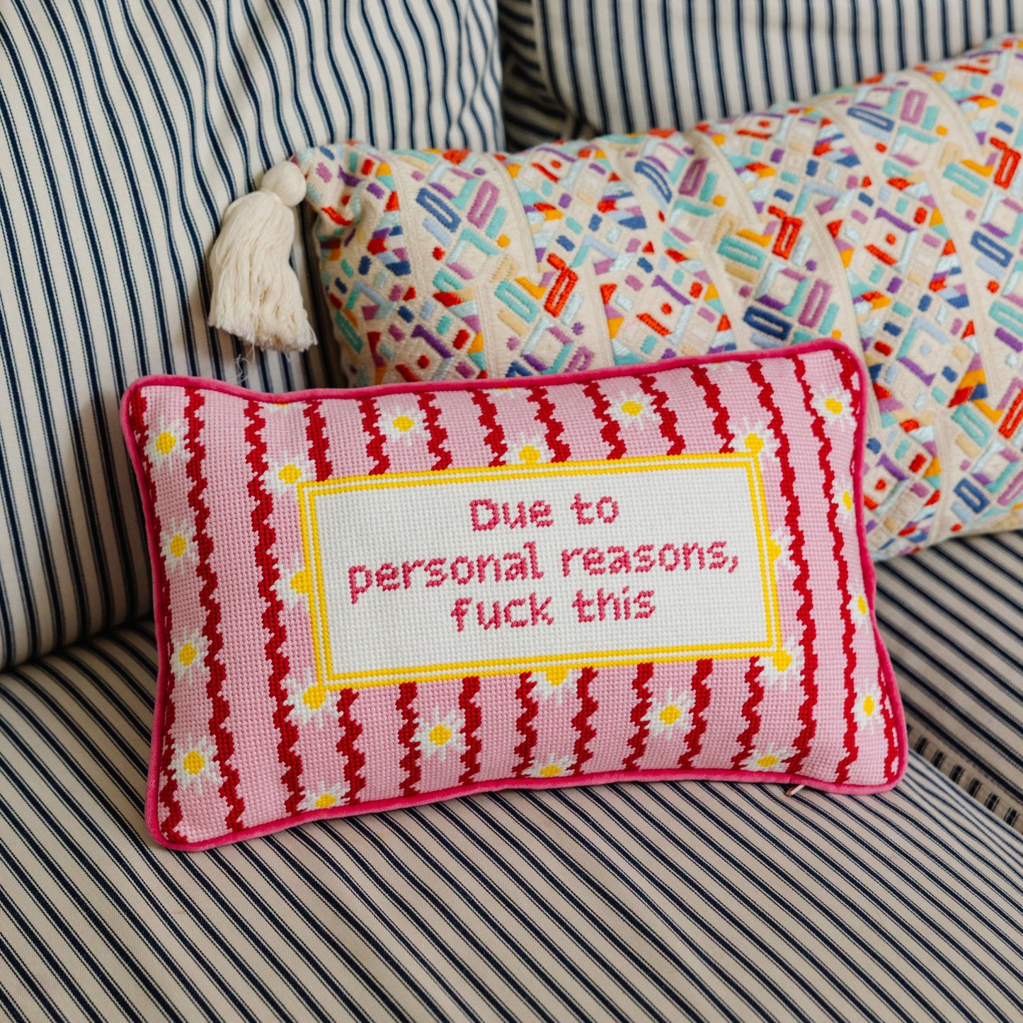 Decorative pillow with text on a striped sofa