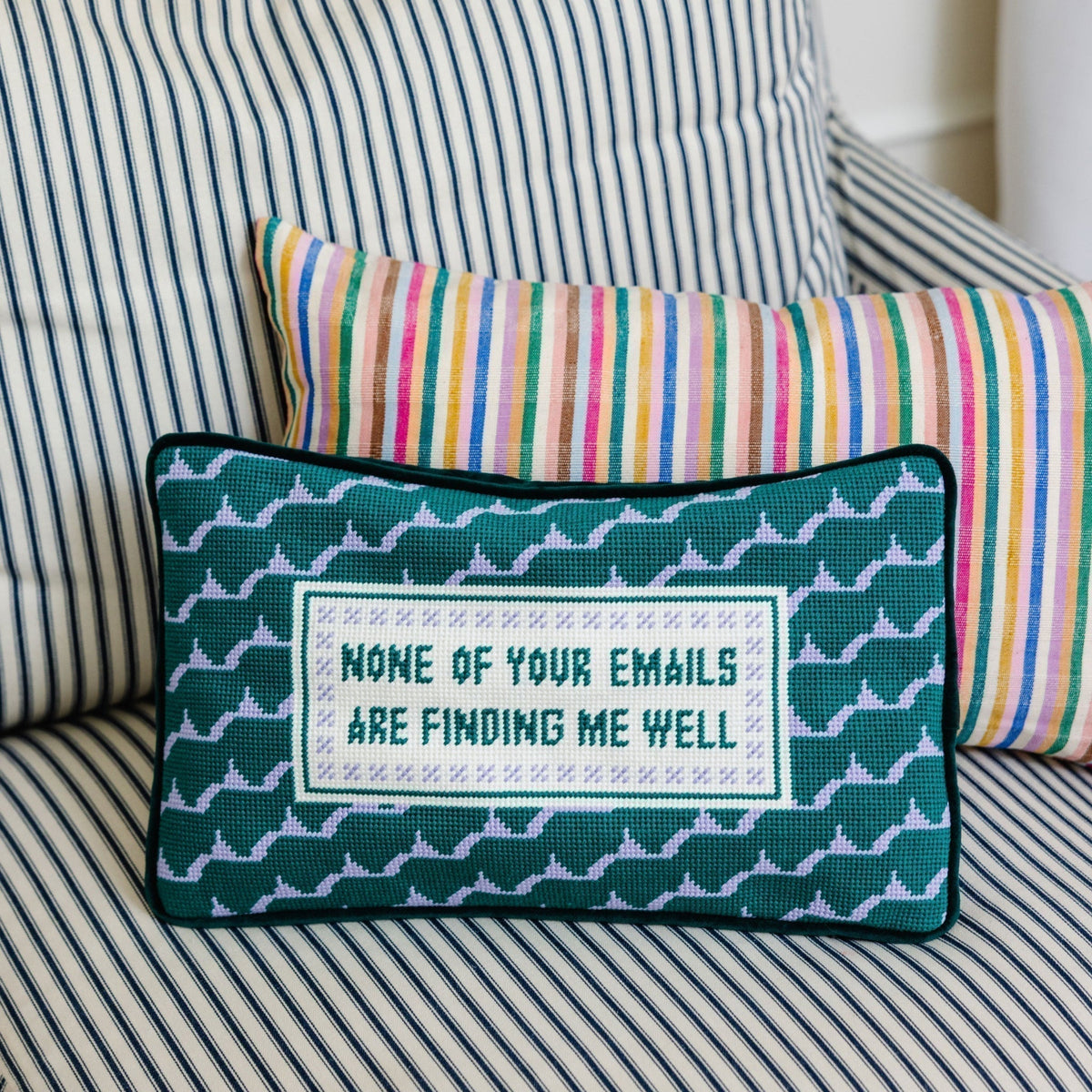 Decorative pillow with text on a striped sofa