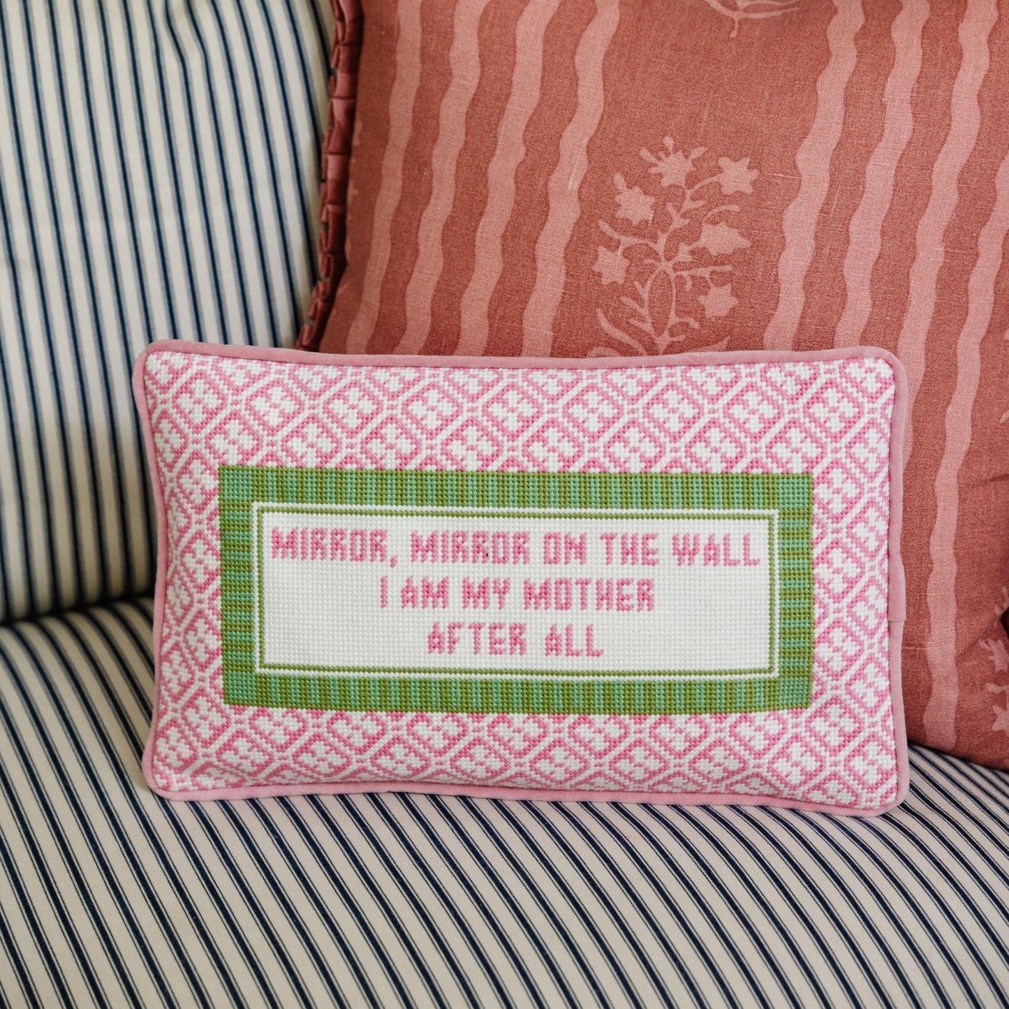 Decorative pillow with text on a striped sofa