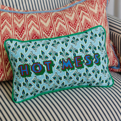 Decorative pillow with 'HOT MESS' text on a striped couch