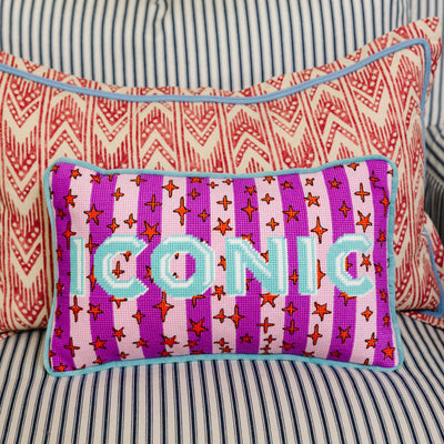 Decorative pillow with 'ICONIC' text on a striped background
