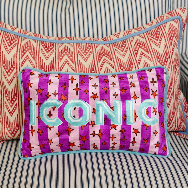 Decorative pillow with 'ICONIC' text on a striped background