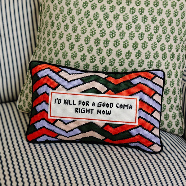 Decorative pillow with colorful zigzag pattern and text on a striped sofa.