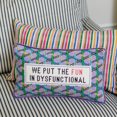 Decorative pillow with colorful text on a striped couch
