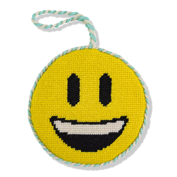 Round yellow smiley face toy with black eyes and mouth, on a white background
