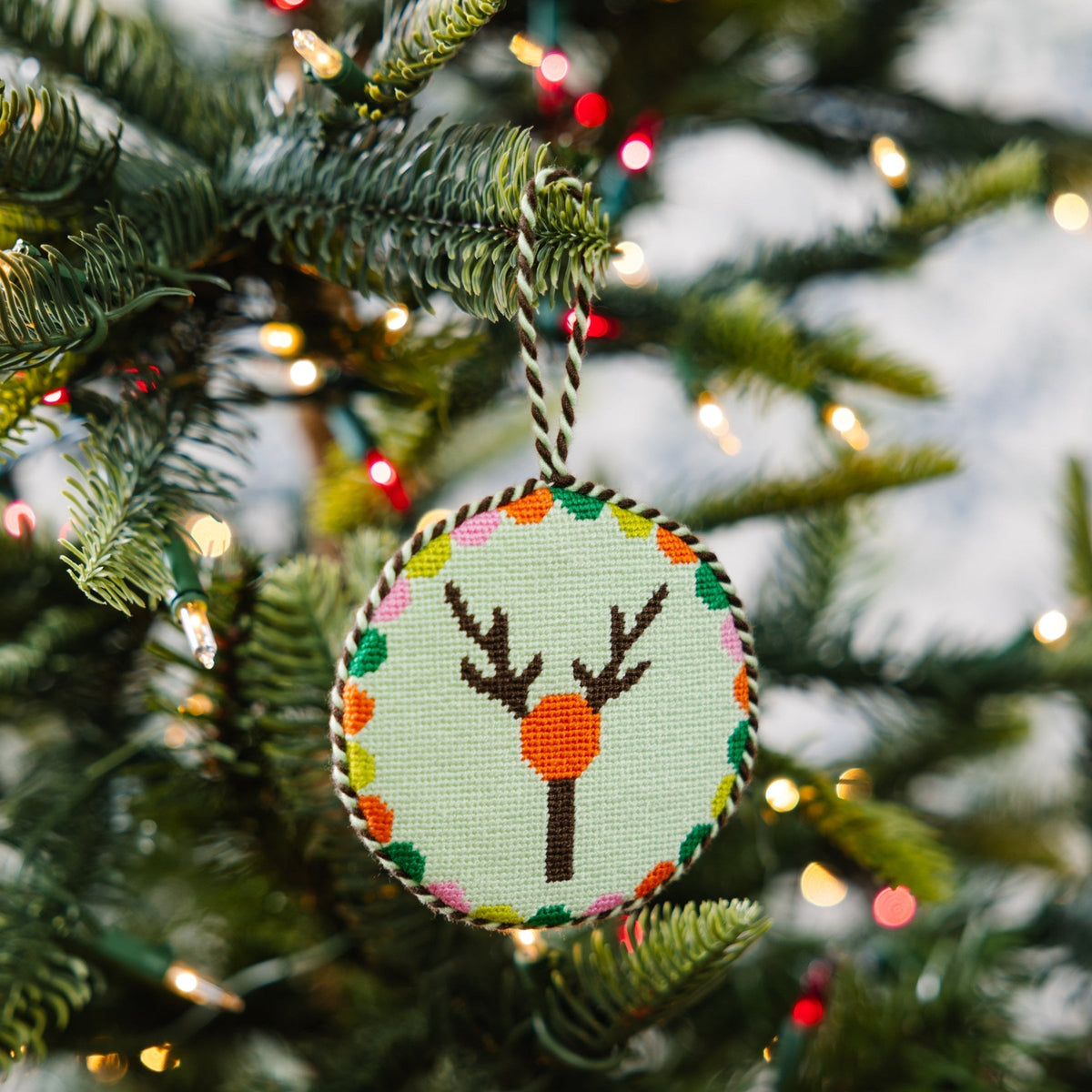 Decorative Christmas ornament with a deer design on a Christmas tree.