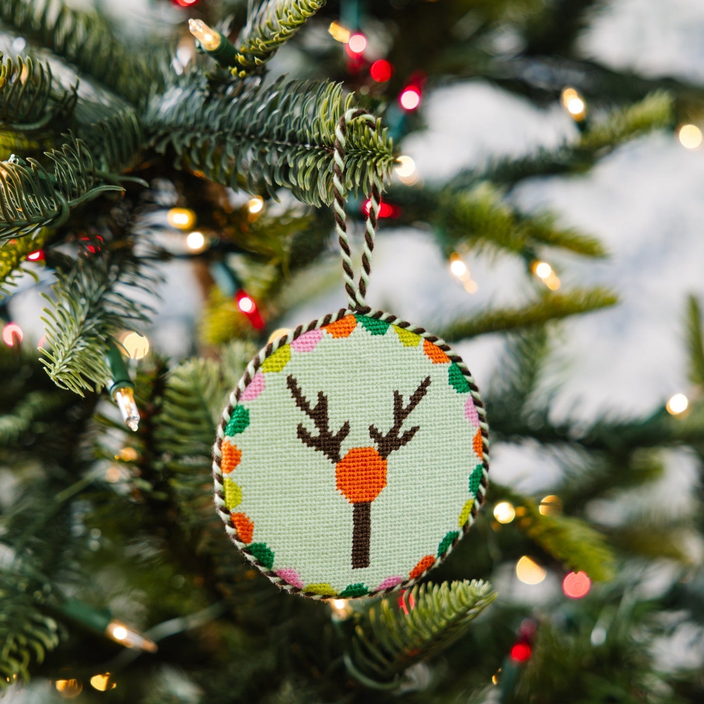 Decorative Christmas ornament with a deer design on a Christmas tree.