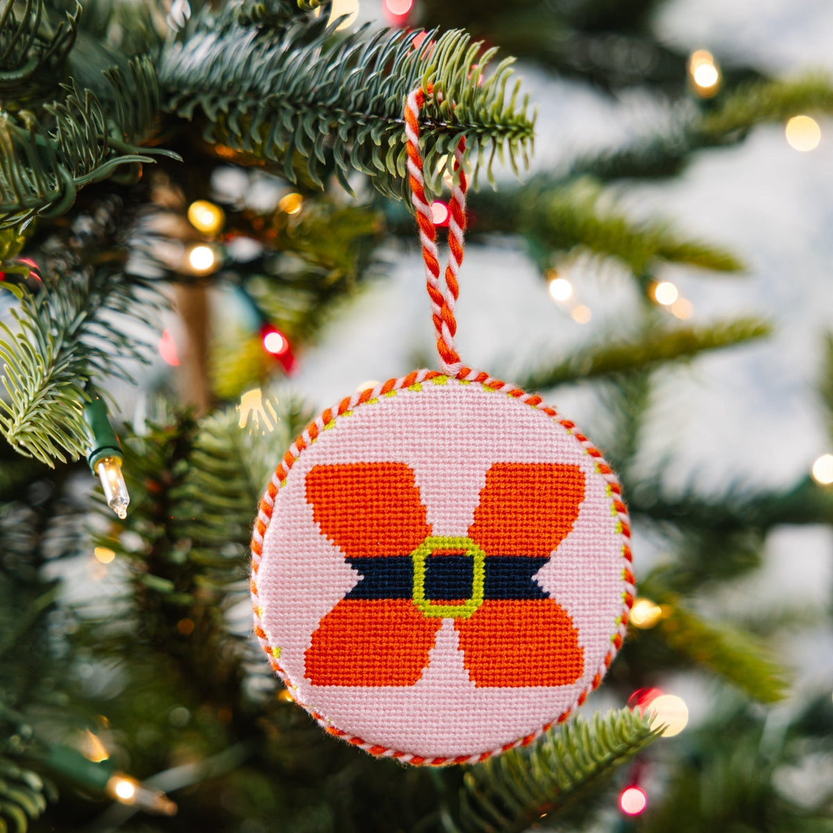 Decorative Christmas ornament with a red and black design on a Christmas tree.