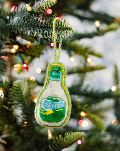 Decorative bottle ornament on a Christmas tree with lights in the background