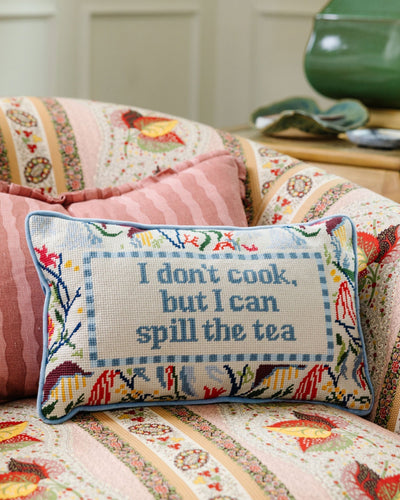 Decorative pillow with floral design and text on a patterned sofa.