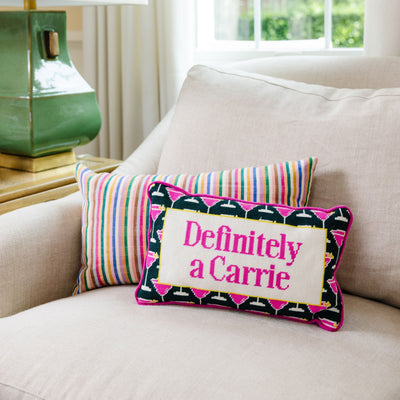 Decorative pillow with 'Definitely a Carrie' text on a couch next to a lamp.