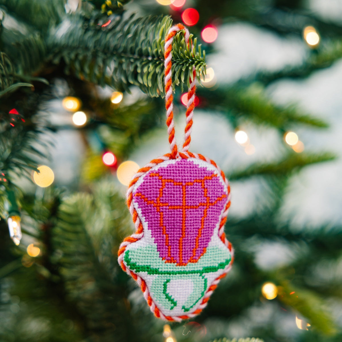 Decorative hot air balloon ornament on a Christmas tree with blurred lights in the background