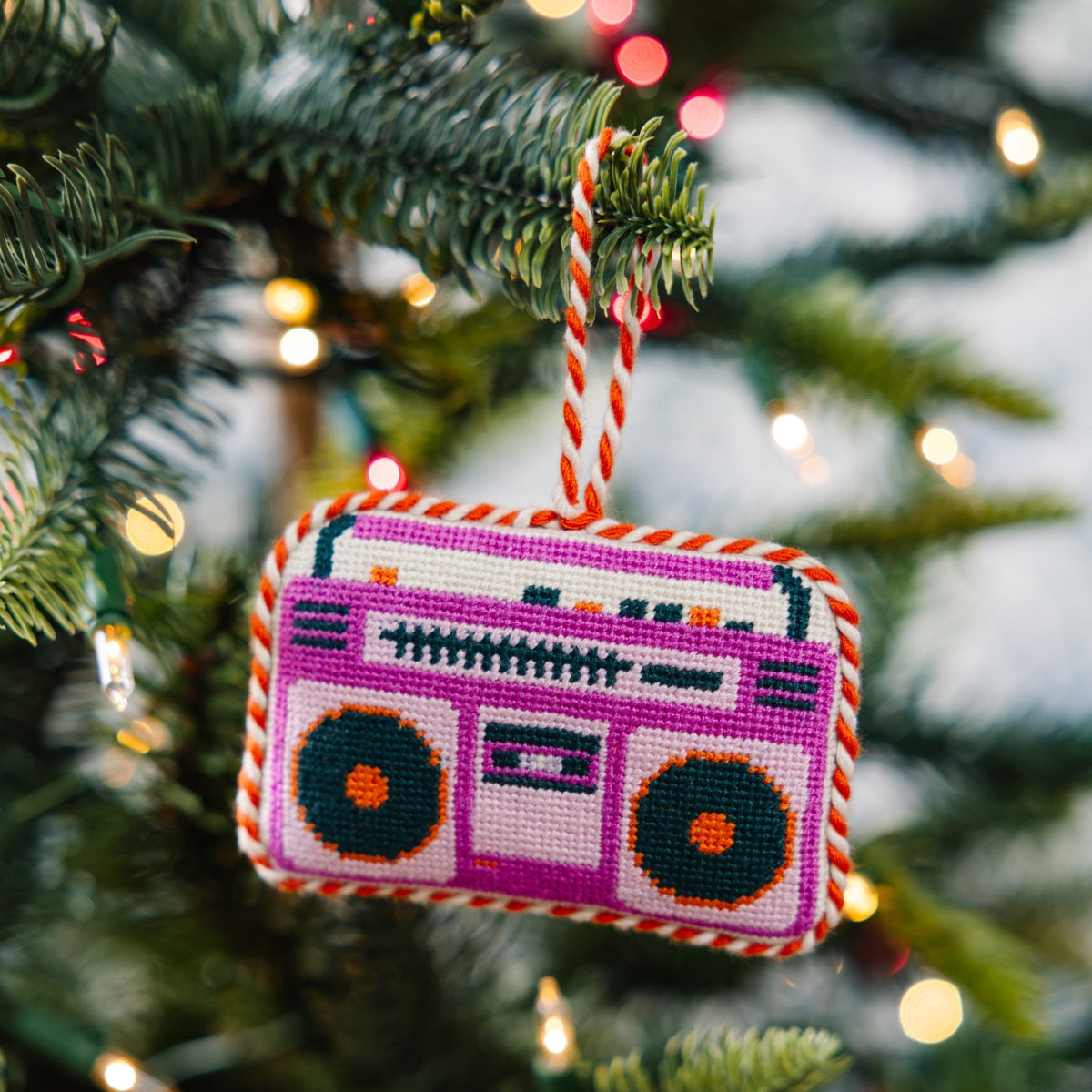 Decorative boombox ornament on a Christmas tree with lights in the background