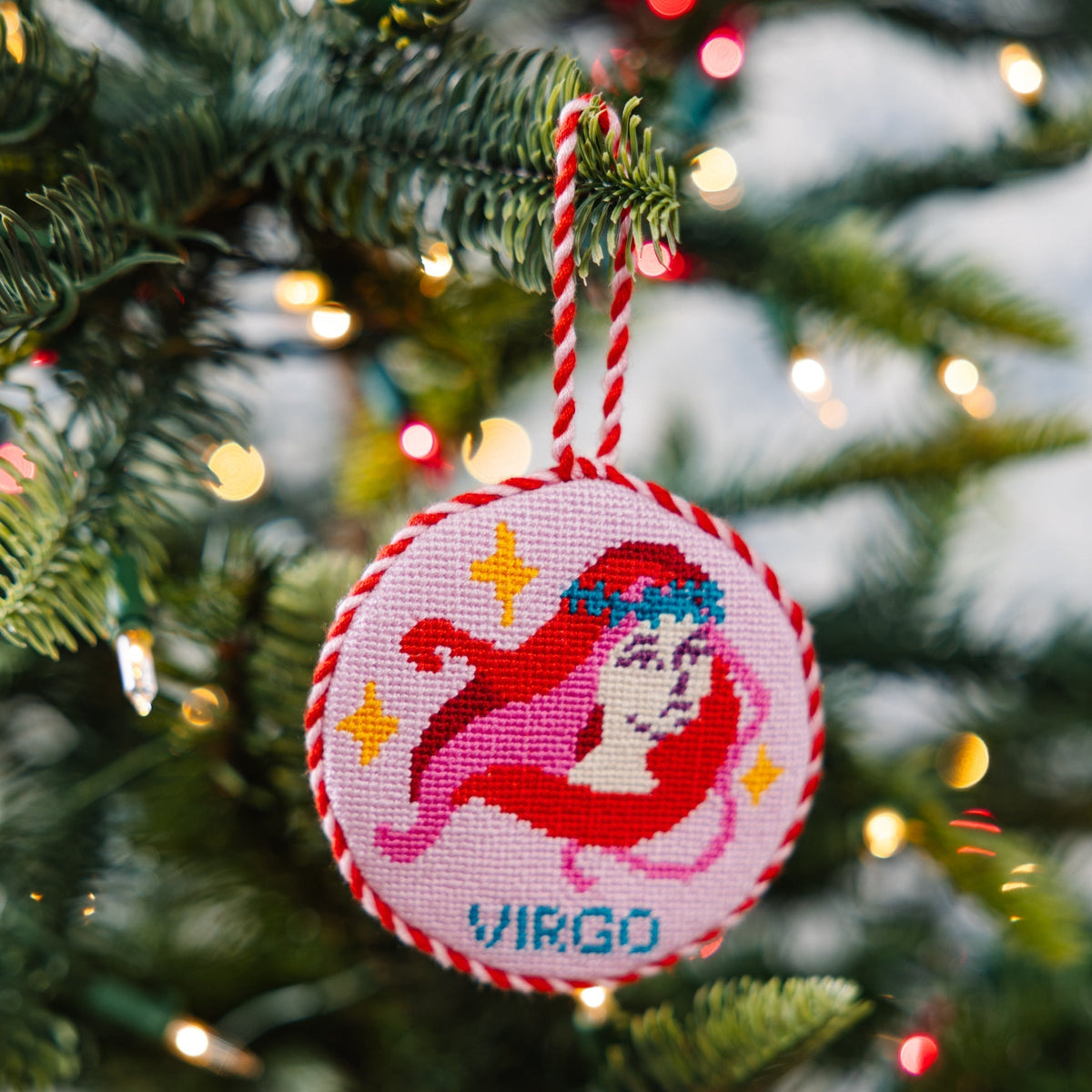 Decorative ornament with a zodiac design hanging on a Christmas tree.