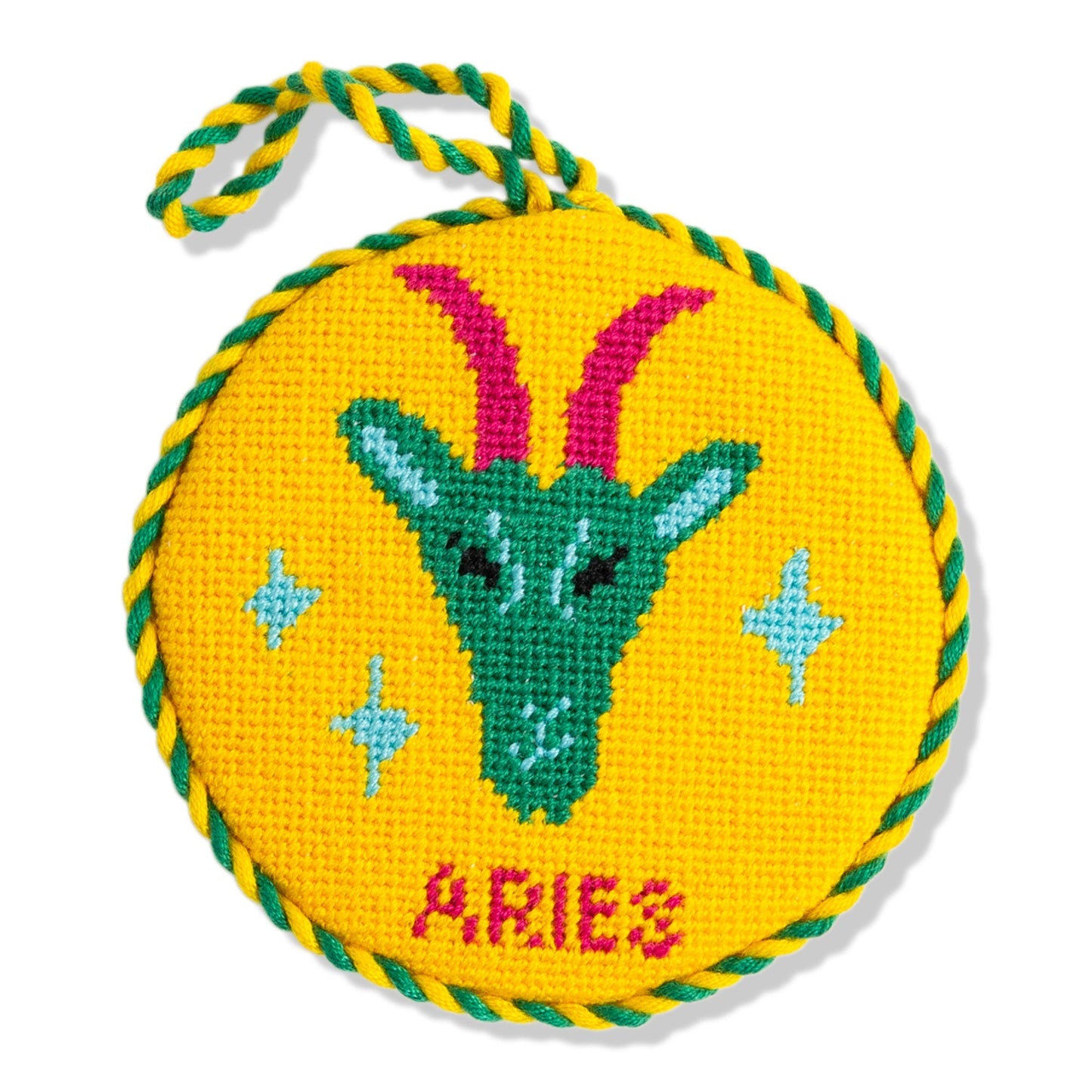 Circular embroidered design of an Aries symbol with colorful border on a yellow background