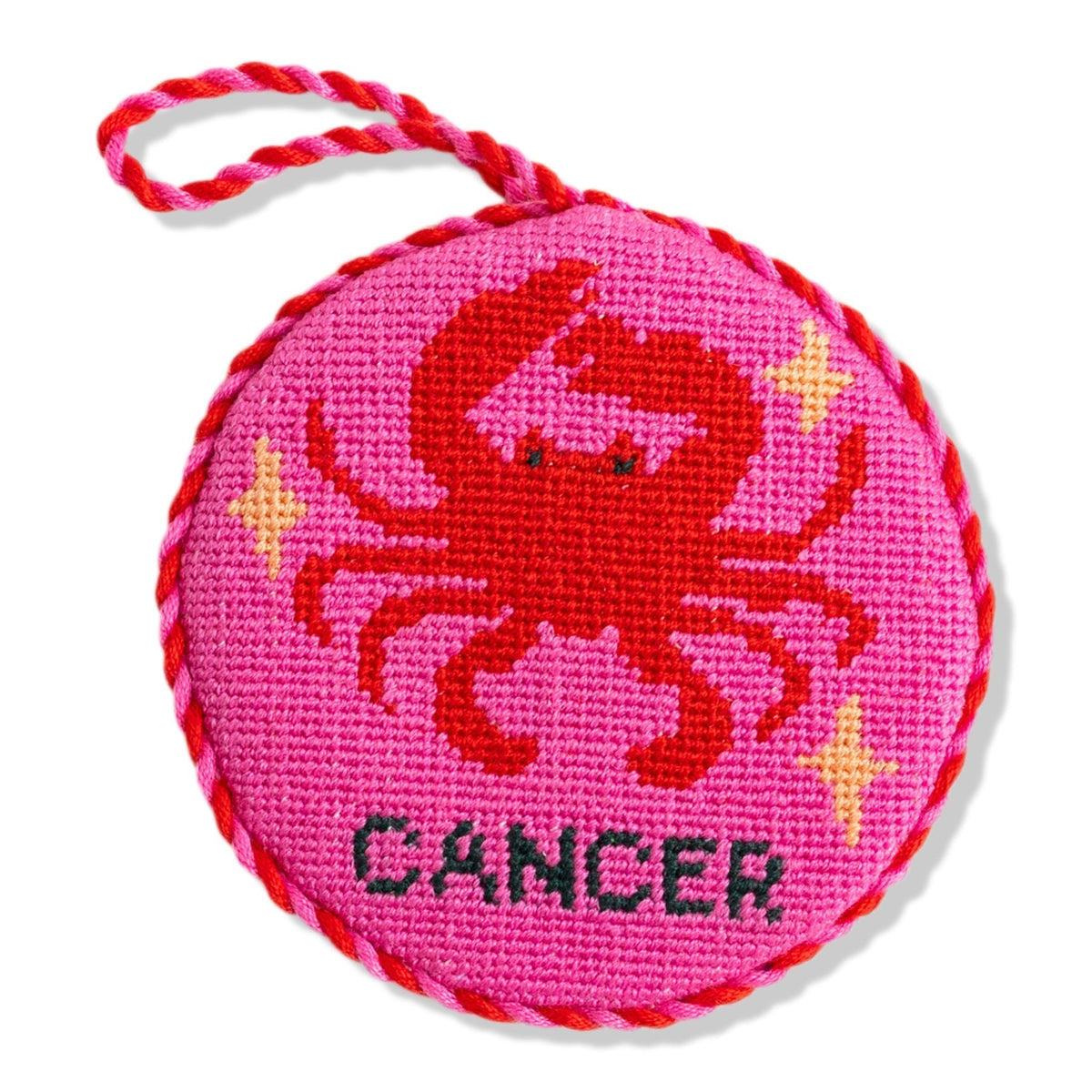 Circular pink object with a crab design and 'Cancer' text on a white background