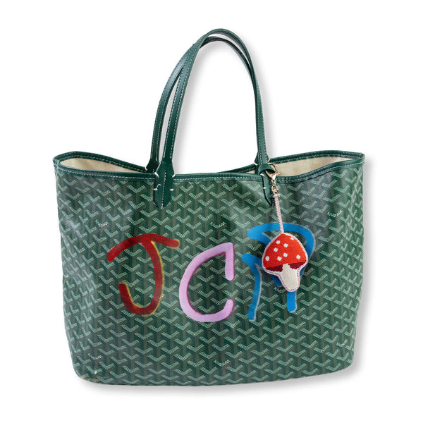 Green patterned tote bag with colorful initials and a mushroom charm on a white background