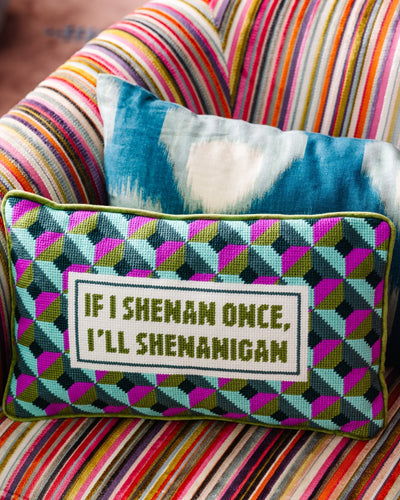 Decorative pillow with text on a colorful striped couch
