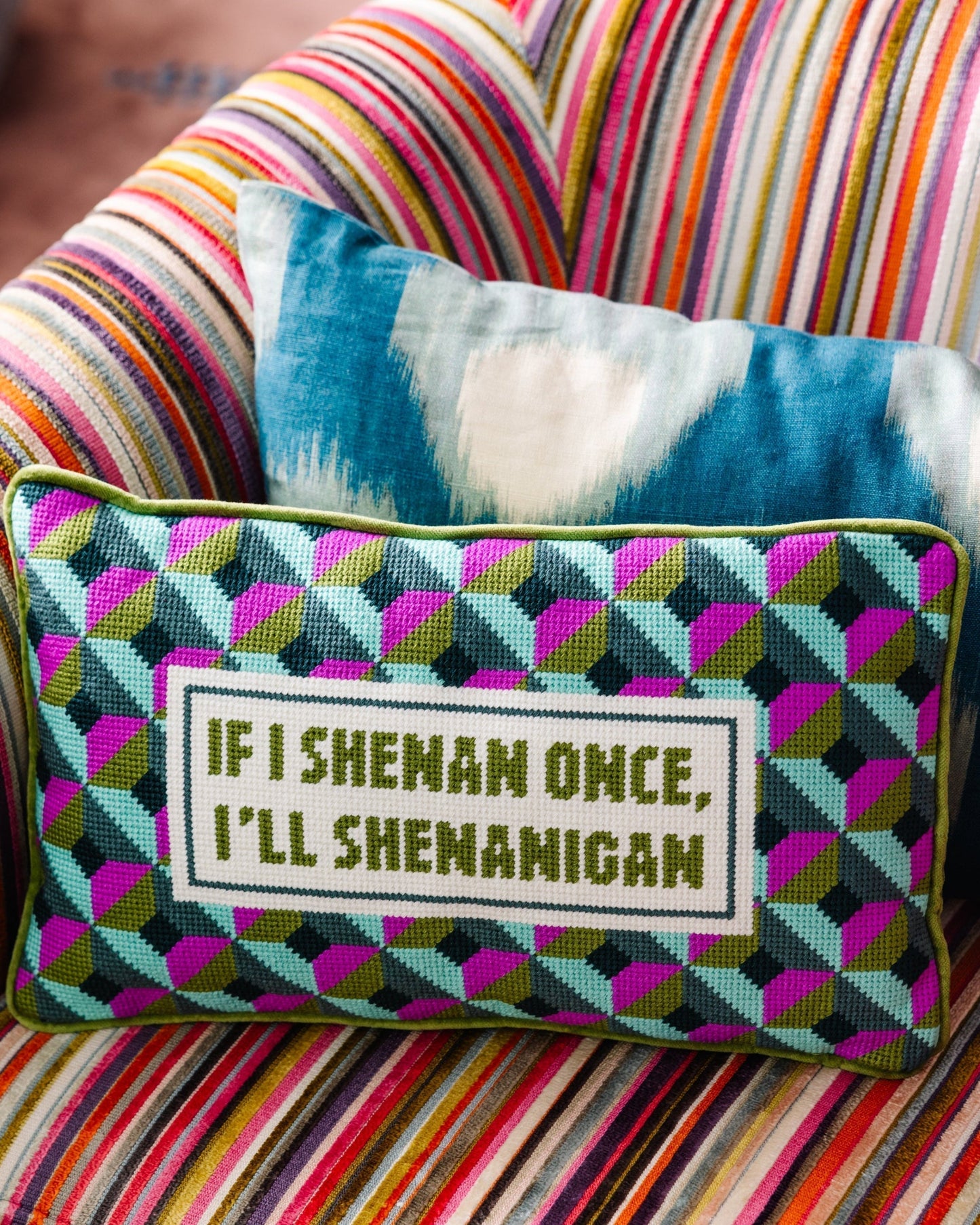 Decorative pillow with text on a colorful striped couch