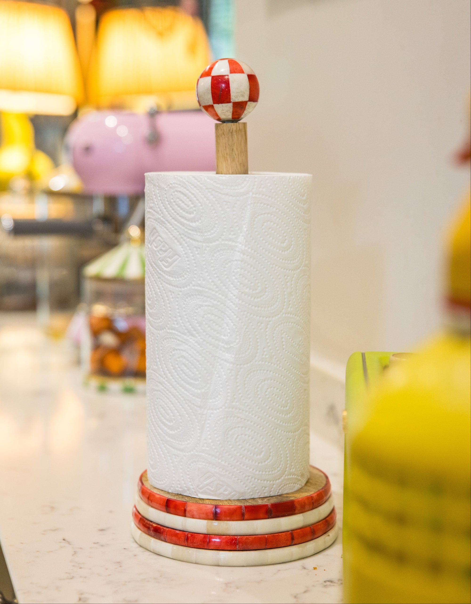 Decorative paper towel holder with a colorful top on a blurred background