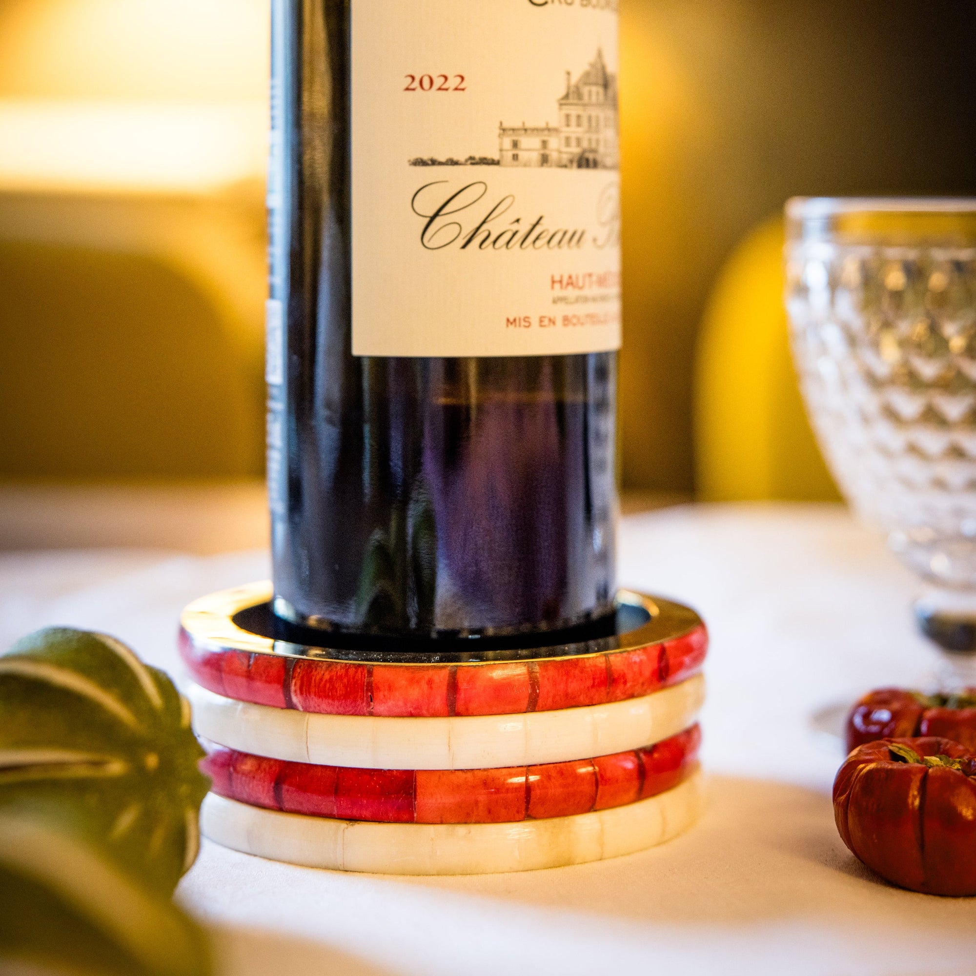 Wine bottle with decorative coaster on a table with a blurred background
