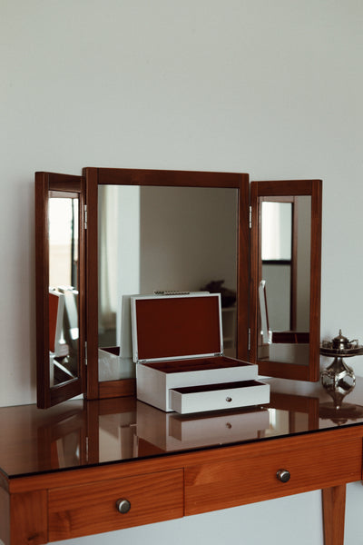 High-gloss white lacquered multi-tiered jewellery organiser with rich contrast velvet interior lining. Vinidec white lacquered tiered jewellery box with open lid and drawer styled on a wooden dressing table