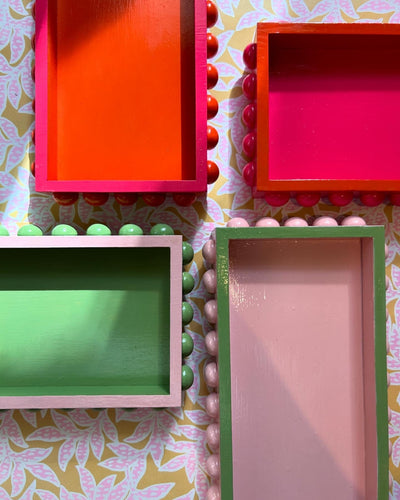 Hand painted bobbin decorative trays in pink, orange and green. 