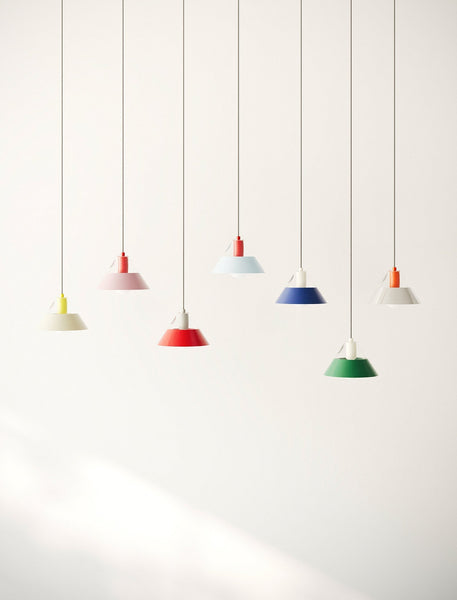 FIFTY FIFTY Lamp group of seven colorful pendant lamps with metal shades hanging against a white wall.