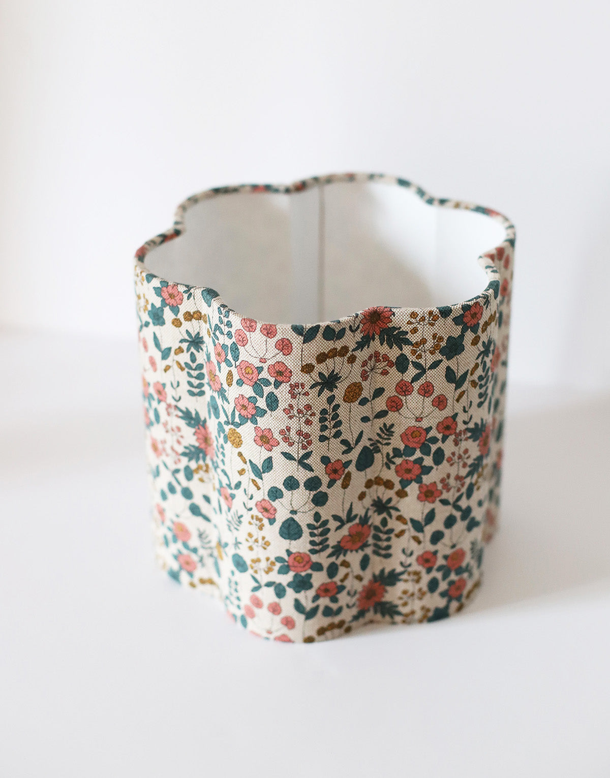 Abat-jour floral en coton beige imprimé fleurs multicolores, fait main, forme cylindrique ondulée.