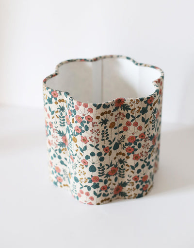Abat-jour floral en coton beige imprimé fleurs multicolores, fait main, forme cylindrique ondulée.