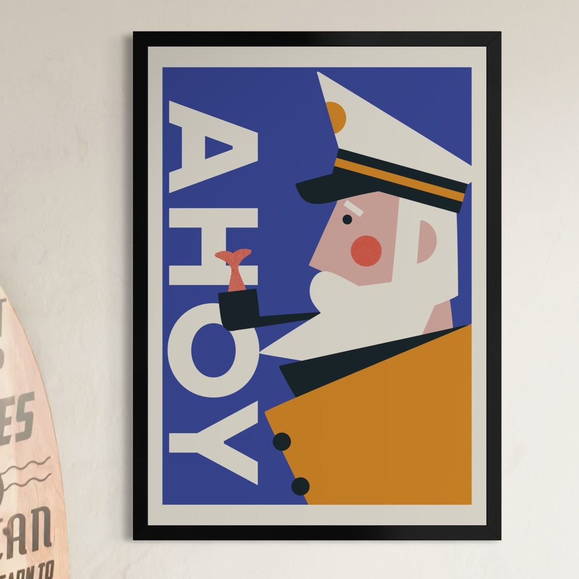 Retro framed poster with a character in a captain's hat and 'AHOY' text on a blue background, displayed on a wall.