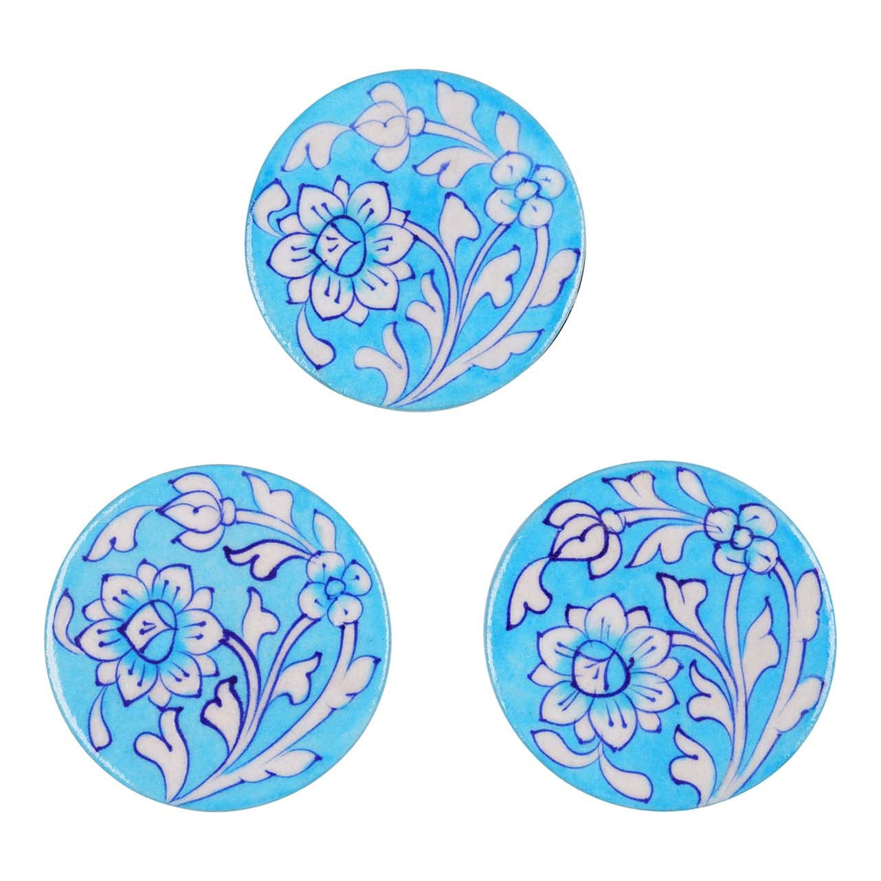 Three round ceramic coasters with blue floral patterns